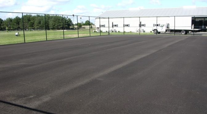 How long should asphalt cure before applying sport surfaces